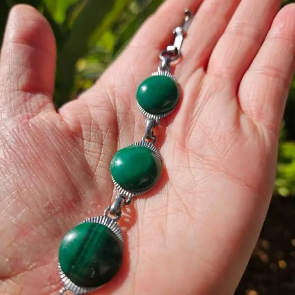Malachite bracelet features natural green gemstones set in a silver colored link